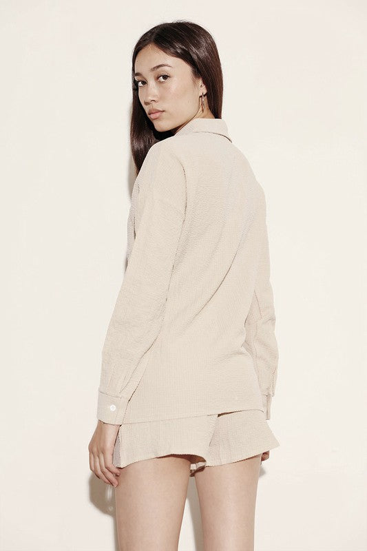 Miss Sparkling relaxed fit button down shorts set in beige worn by a woman shown from the back