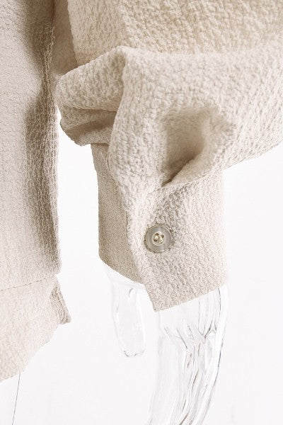 Close-up of sleeve cuff with button on beige relaxed fit button down shorts set by Miss Sparkling