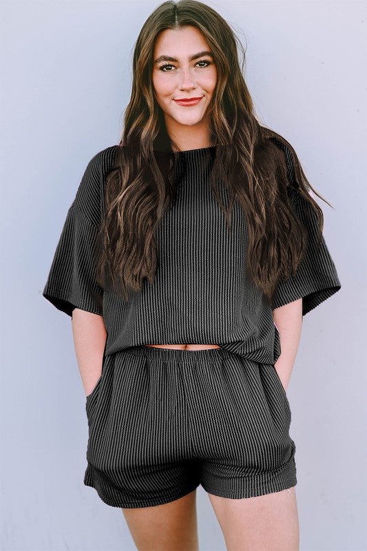 Woman wearing black ribbed textured matching set for women with short sleeves and shorts
