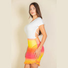 Woman wearing a colorful ruched mesh mini skirt with ruffle hem paired with a white fitted top