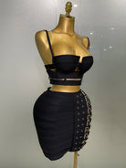 Black sexy club outfit for women featuring a strappy crop top and high-waisted skirt with buckle details