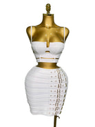 White sexy club outfit for women with strappy crop top and buckle detailed mini skirt on gold mannequin