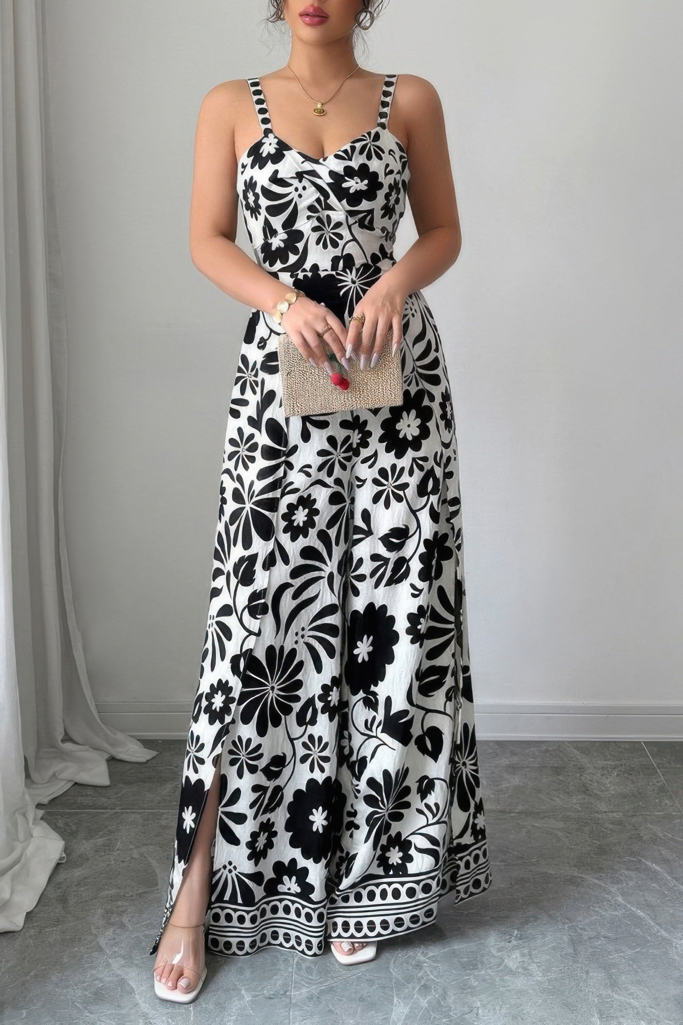 Stylish black and white floral wide leg vacation jumpsuit with side slits and adjustable straps
