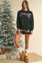 Womens cozy Christmas matching set featuring black sweatshirt and shorts with festive light designs
