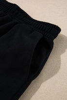 Close-up of black elastic waistband pants from womens cozy Christmas matching set by SHEWIN INC