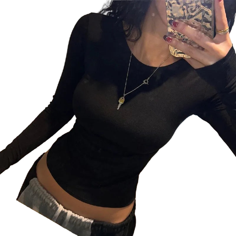 Woman wearing a black backless crop top for women with long sleeves and round neckline
