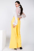 VacationGrabs women's yellow side slit trousers vacation styled with a white sheer blouse and black heels