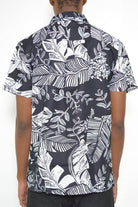 Men's black and white button down for men featuring a tropical leaf pattern on the back