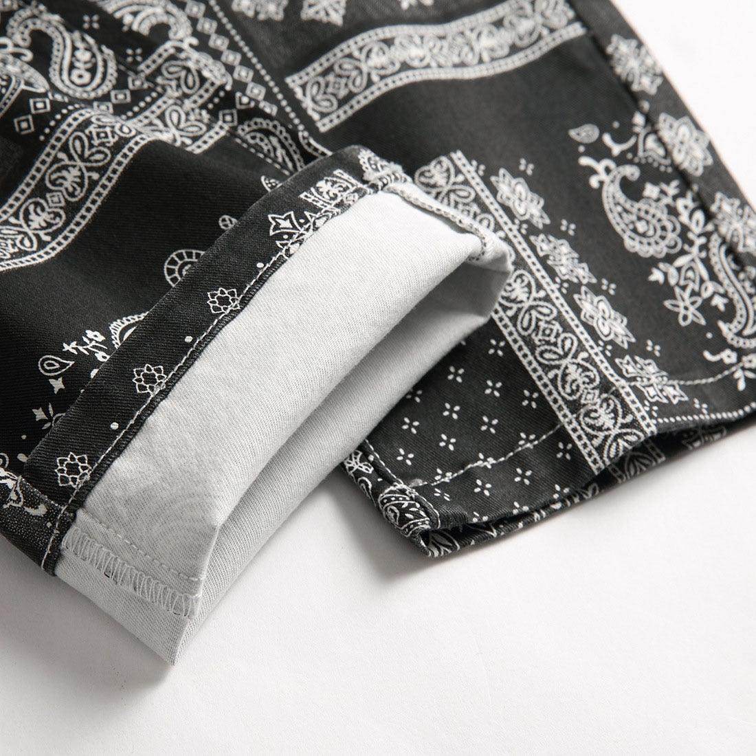 Close-up of VacationGrabs black printed jeans for men with intricate paisley design and cuff detail