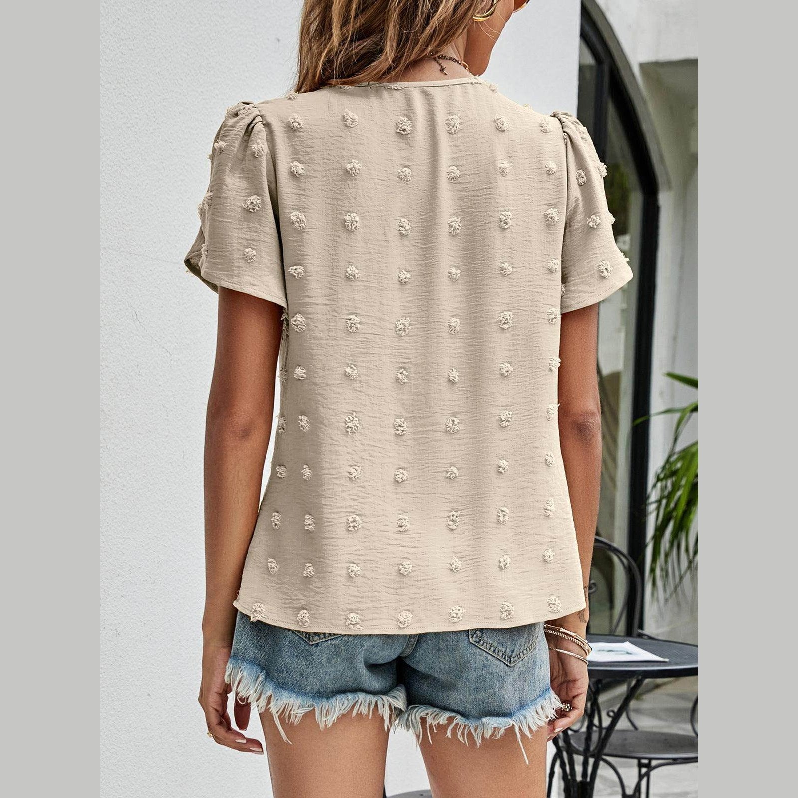 Back view of a casual pink Swiss dot top paired with denim shorts for a trendy look