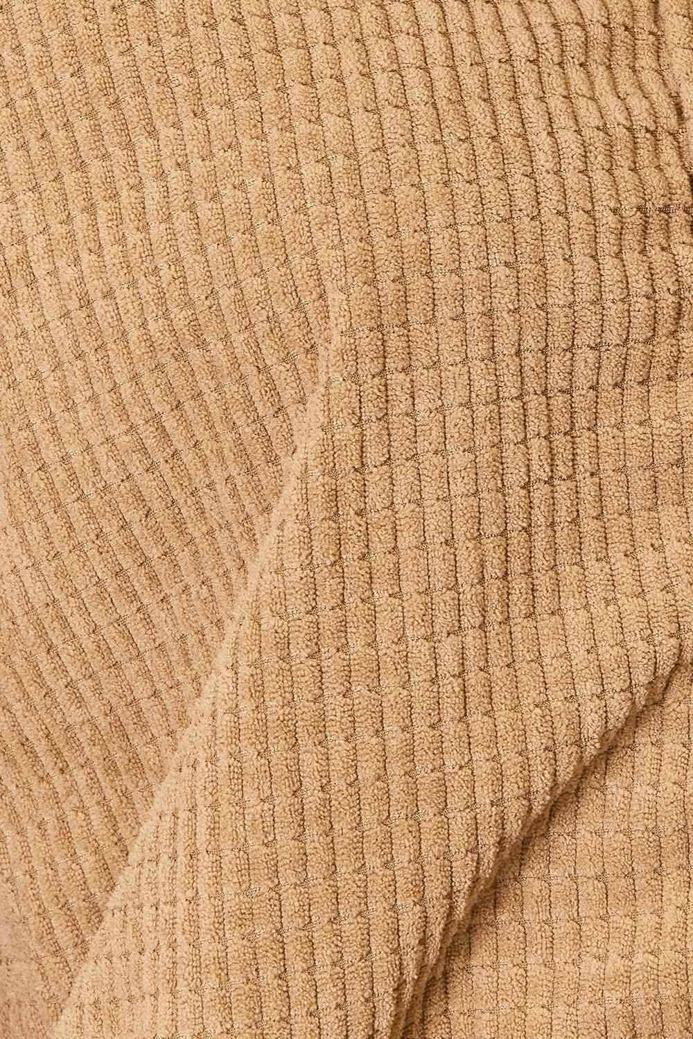 Close-up of a textured beige women's casual vacation jacket featuring a soft ribbed design