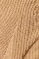 Close-up of a textured beige women's casual vacation jacket featuring a soft ribbed design