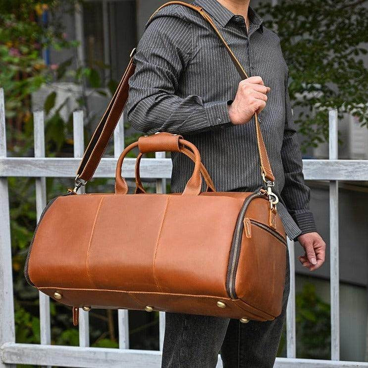 Brown foldable leather suit bag with adjustable shoulder strap for travel convenience