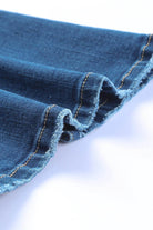 Close-up of the hem detailing on VacationGrabs high rise flare jeans in blue denim fabric