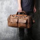 Brown leather travel duffel bag with multiple pockets and sturdy handles for easy carrying