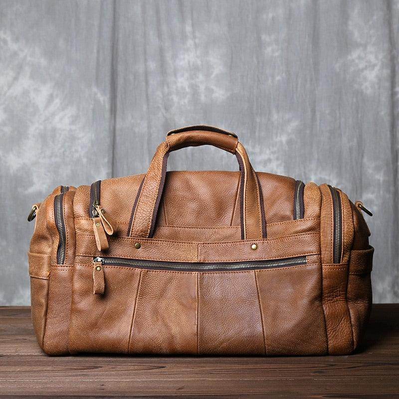 Stylish leather travel duffel bag in tan with multiple pockets and sturdy handles