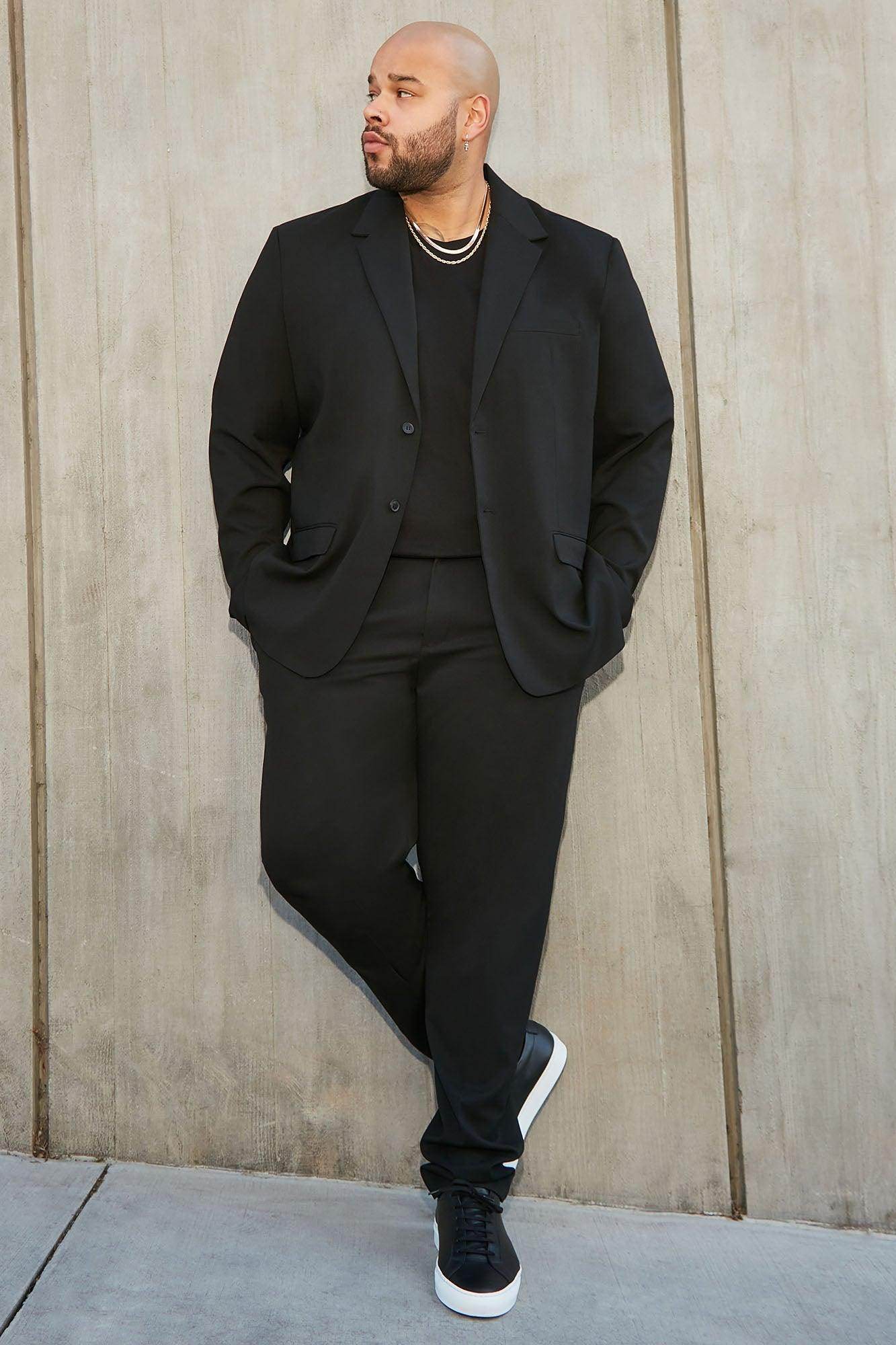 Stylish black modern suit jacket for men paired with matching trousers and sneakers for a contemporary look