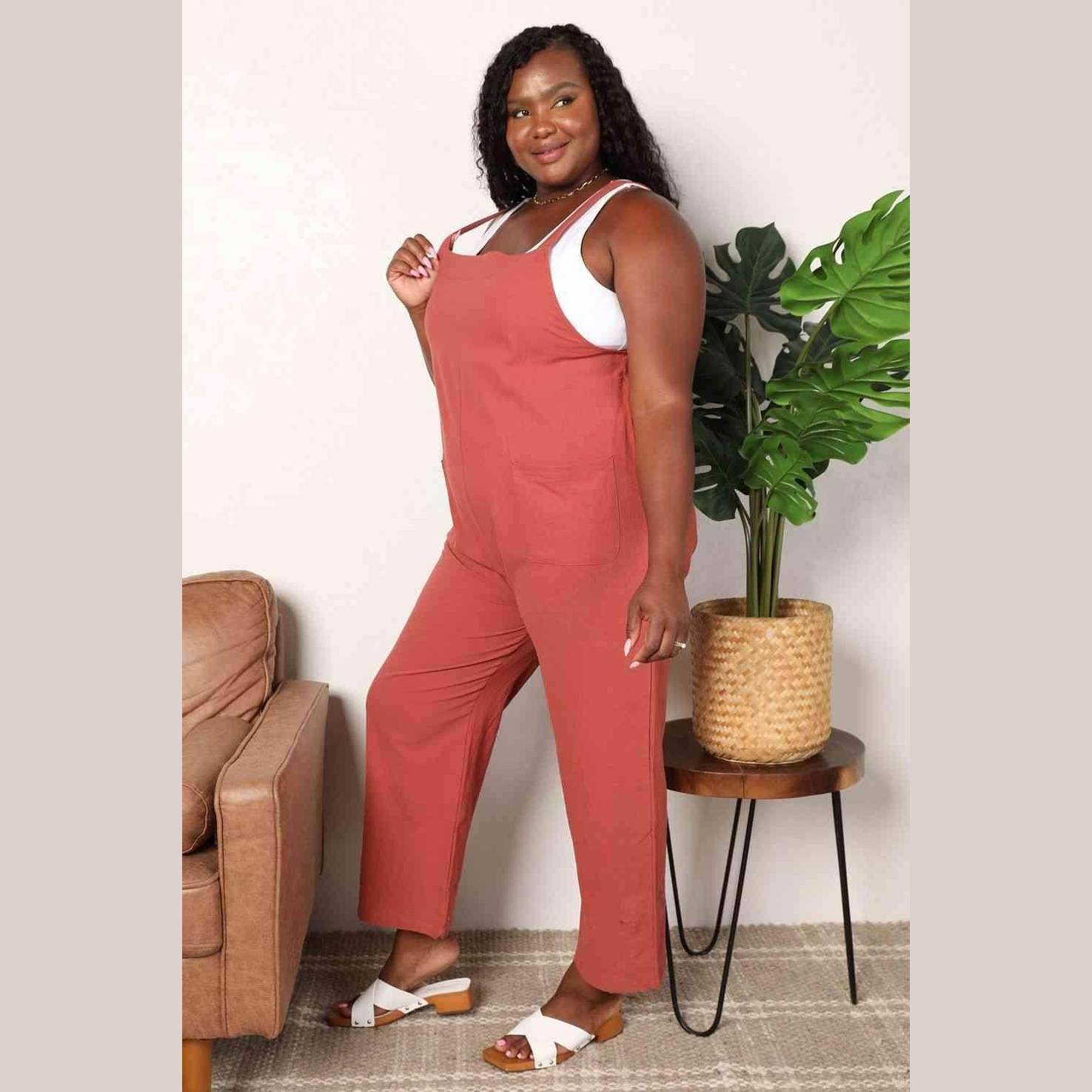 Plus-size woman wearing stylish vacation overalls in rust color with a comfortable fit for summer outings