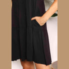 Close-up of a black tiered summer dress with functional pockets, ideal for warm weather outings