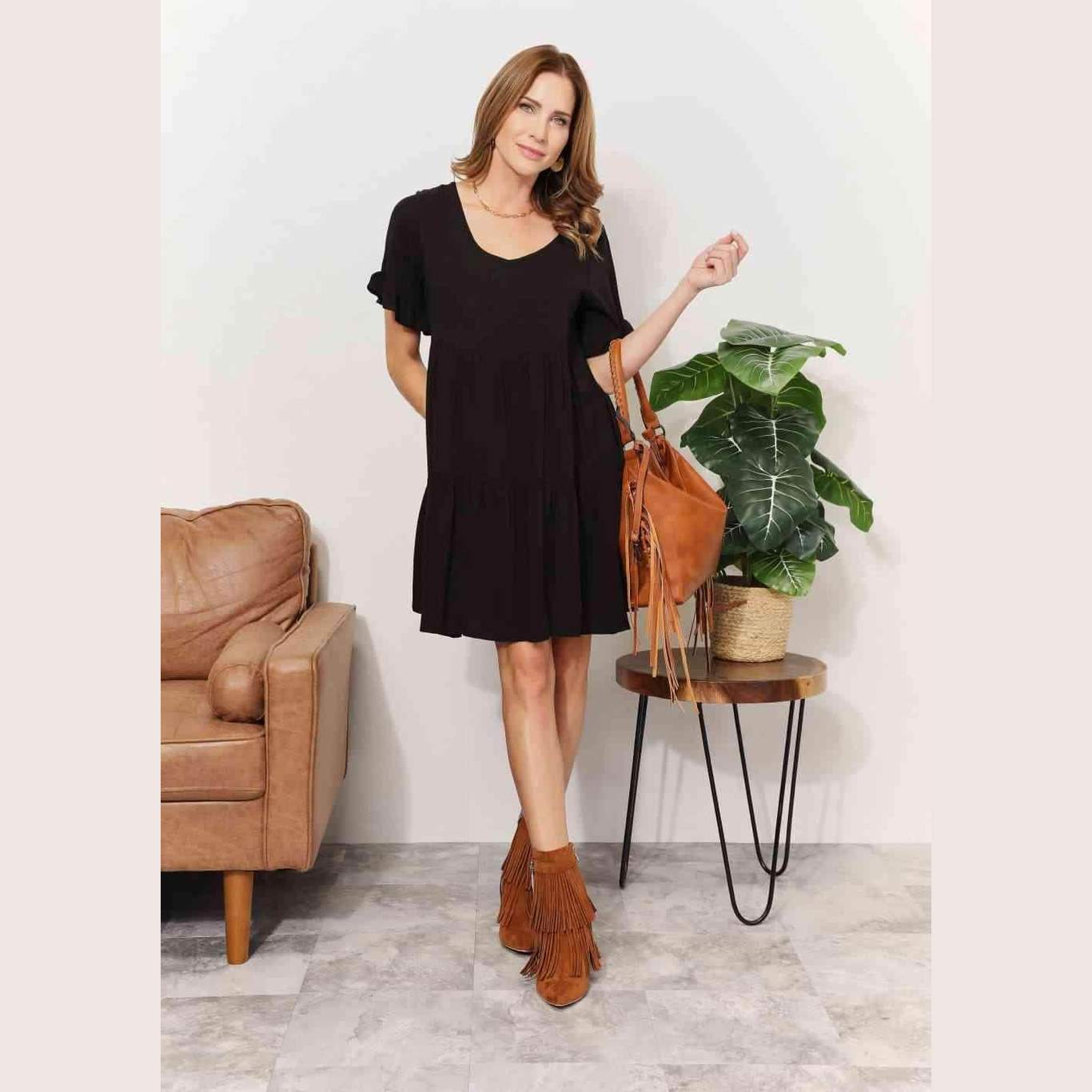 Trendsi black tiered summer dress with short sleeves, paired with a stylish fringe handbag and ankle boots