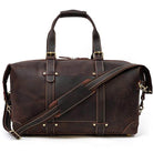 Vacation style leather bag in dark brown with sturdy handles and adjustable shoulder strap