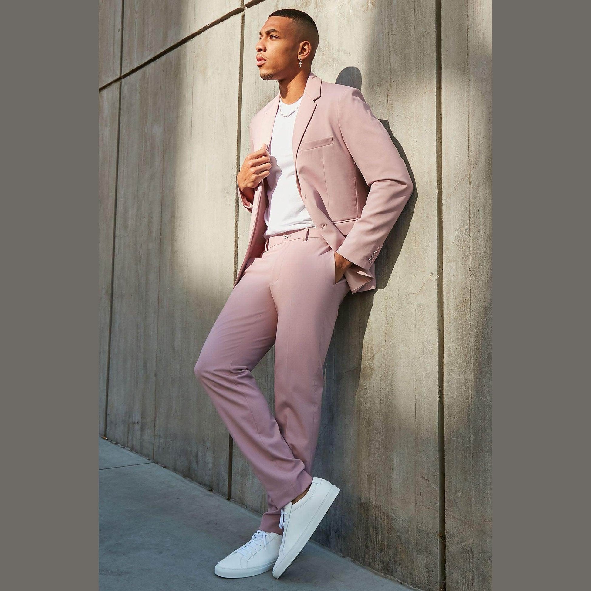Men's vacation style jacket in light pink paired with matching pants and white sneakers for a trendy look
