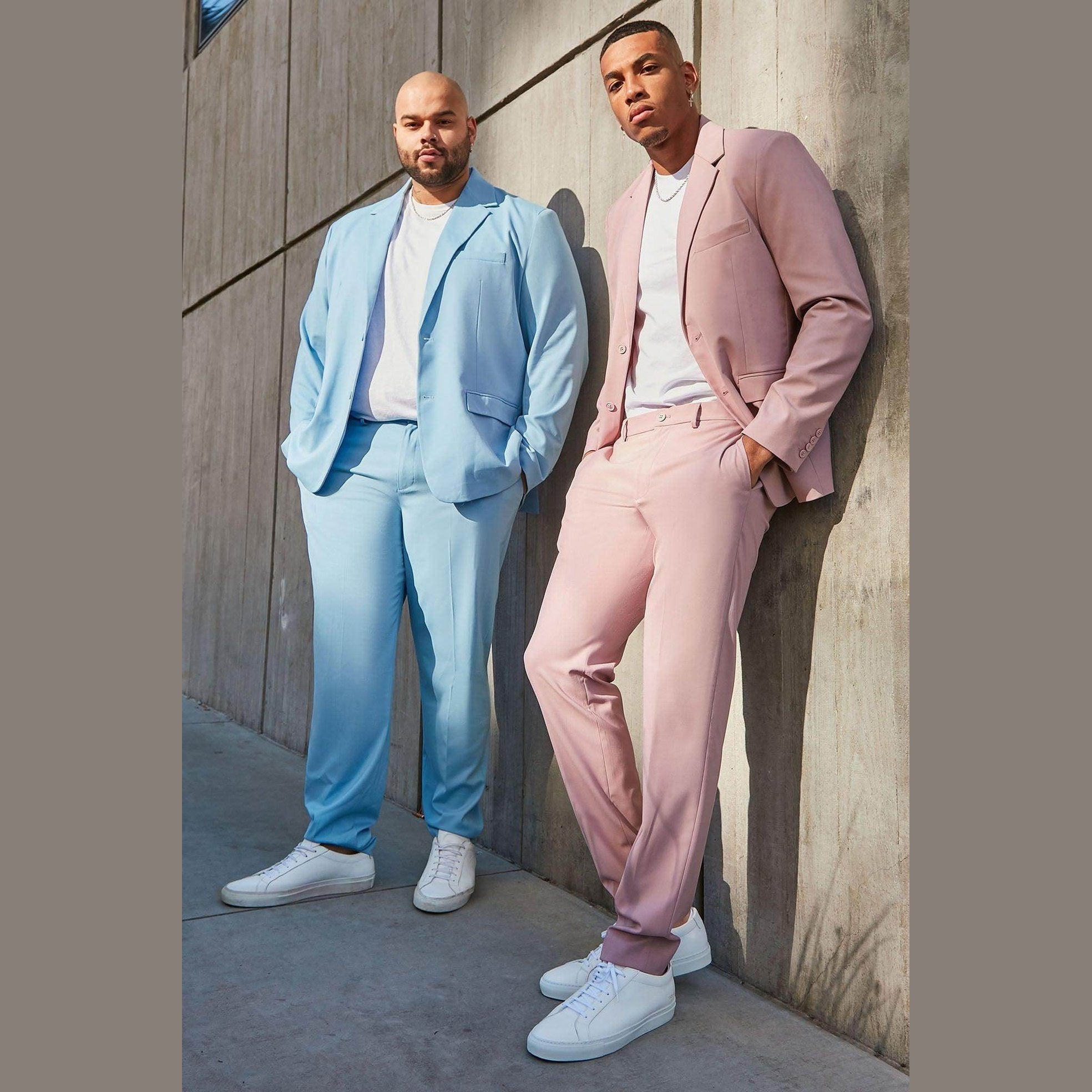 Men's vacation style jacket in light blue and pink worn by models against a concrete wall