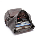 Vintage canvas travel backpack with spacious interior, perfect for holding laptops and books.