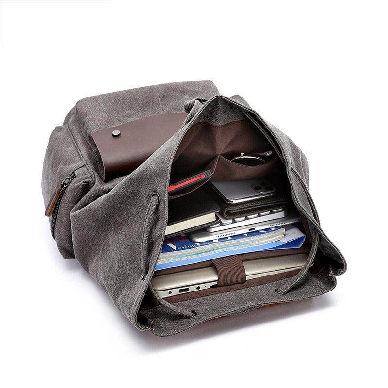 Vintage canvas travel backpack with spacious interior, perfect for holding laptops and books.