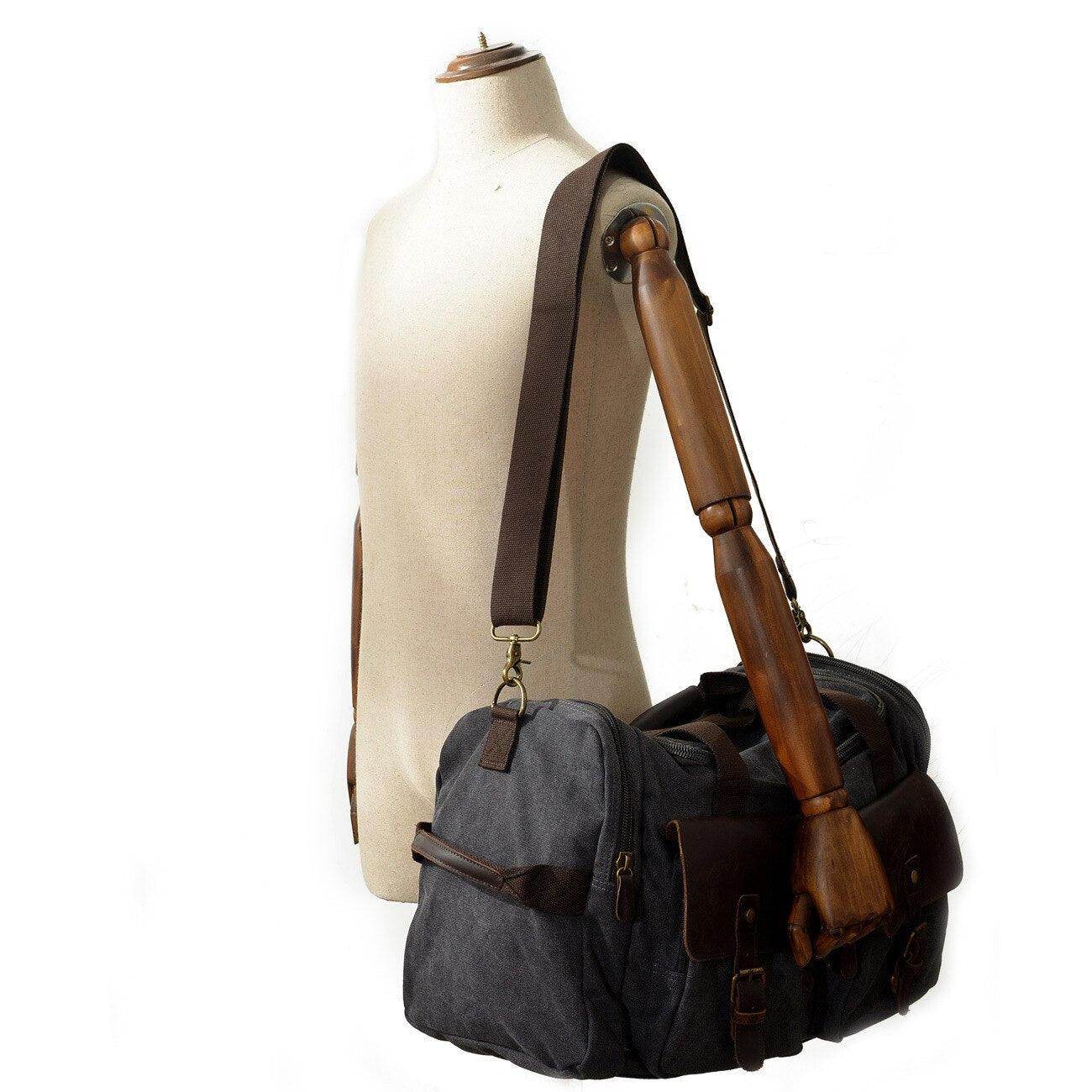 Stylish gray weekender outdoor duffel bag with brown leather accents and adjustable shoulder strap