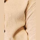 Beige woven long sleeve sweater with a relaxed fit and button details for casual wear