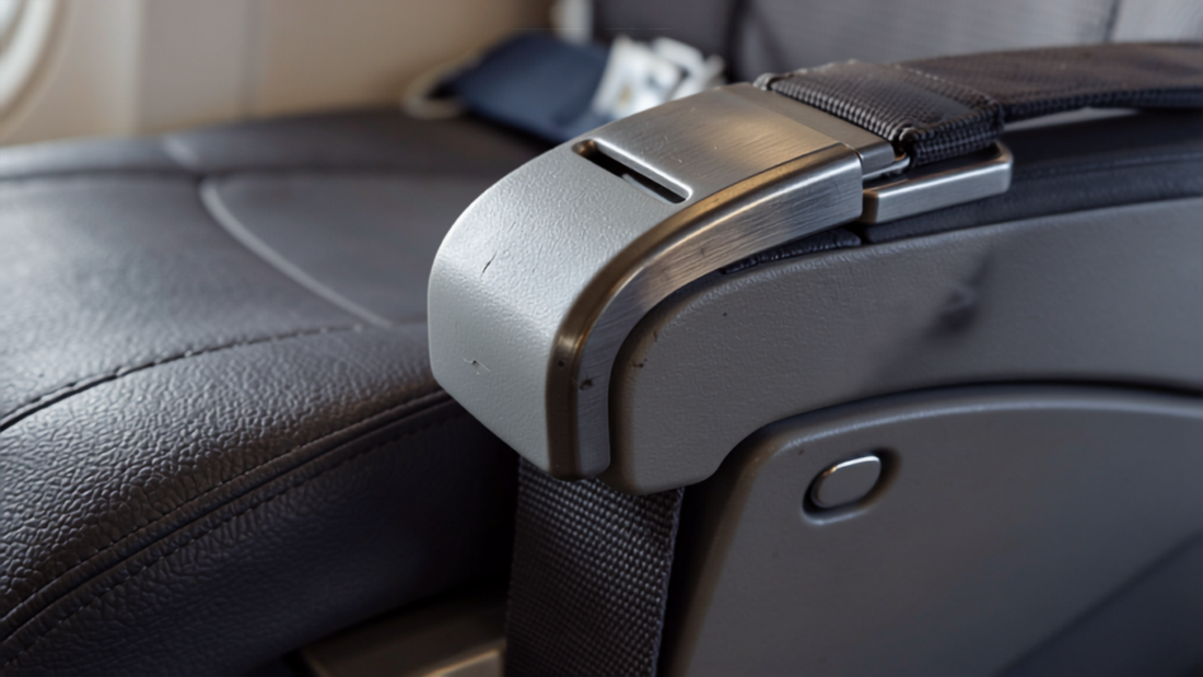 Close-up of an airplane seatback tray table and seatbelt buckle