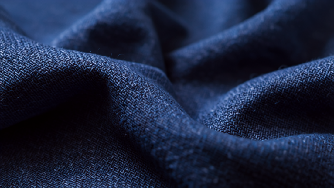 Close-up of vivid Klein blue fabric texture with bold saturated color and soft folds