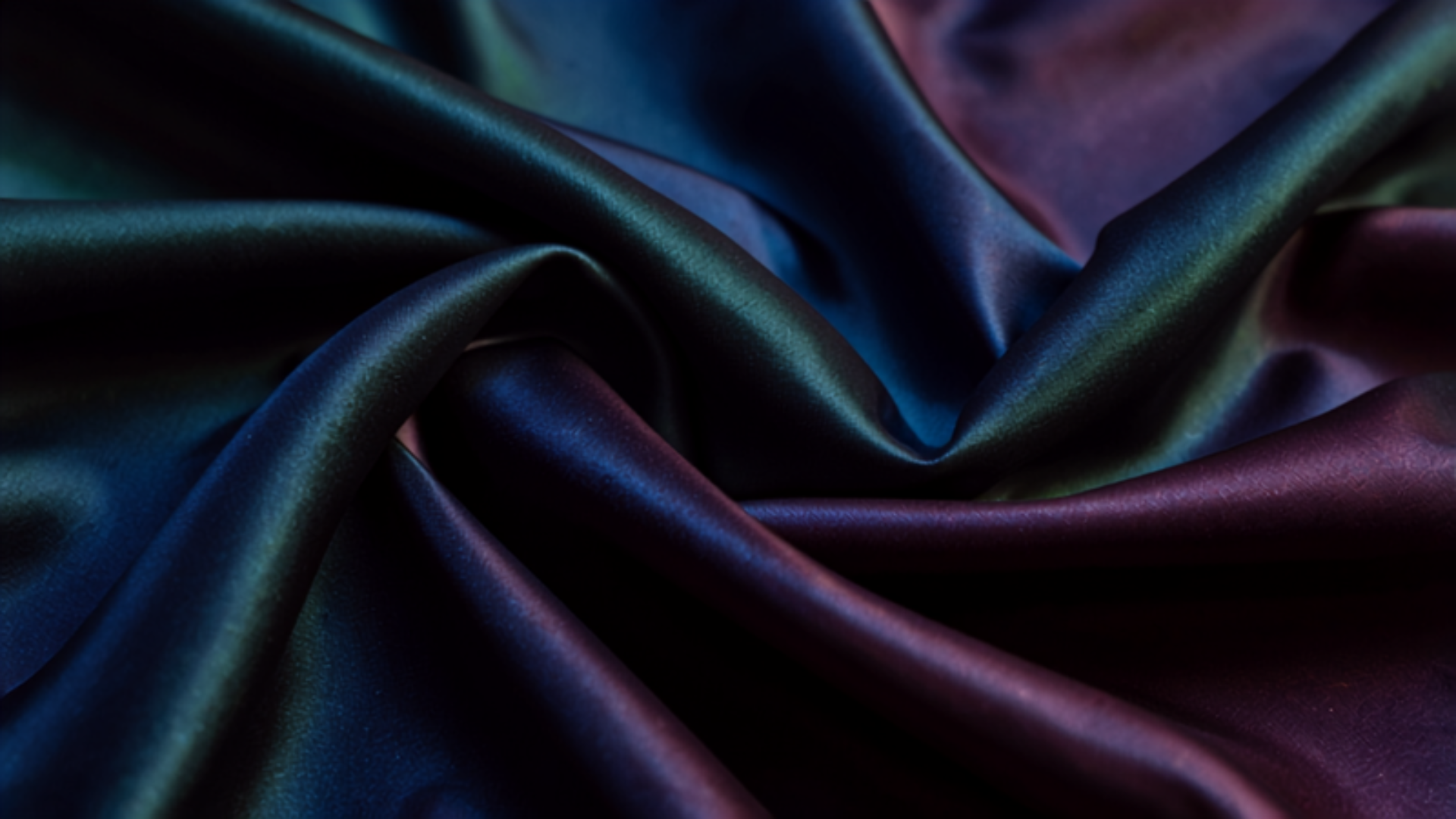 Close-up of dark satin fabric with luxurious sheen and draped folds