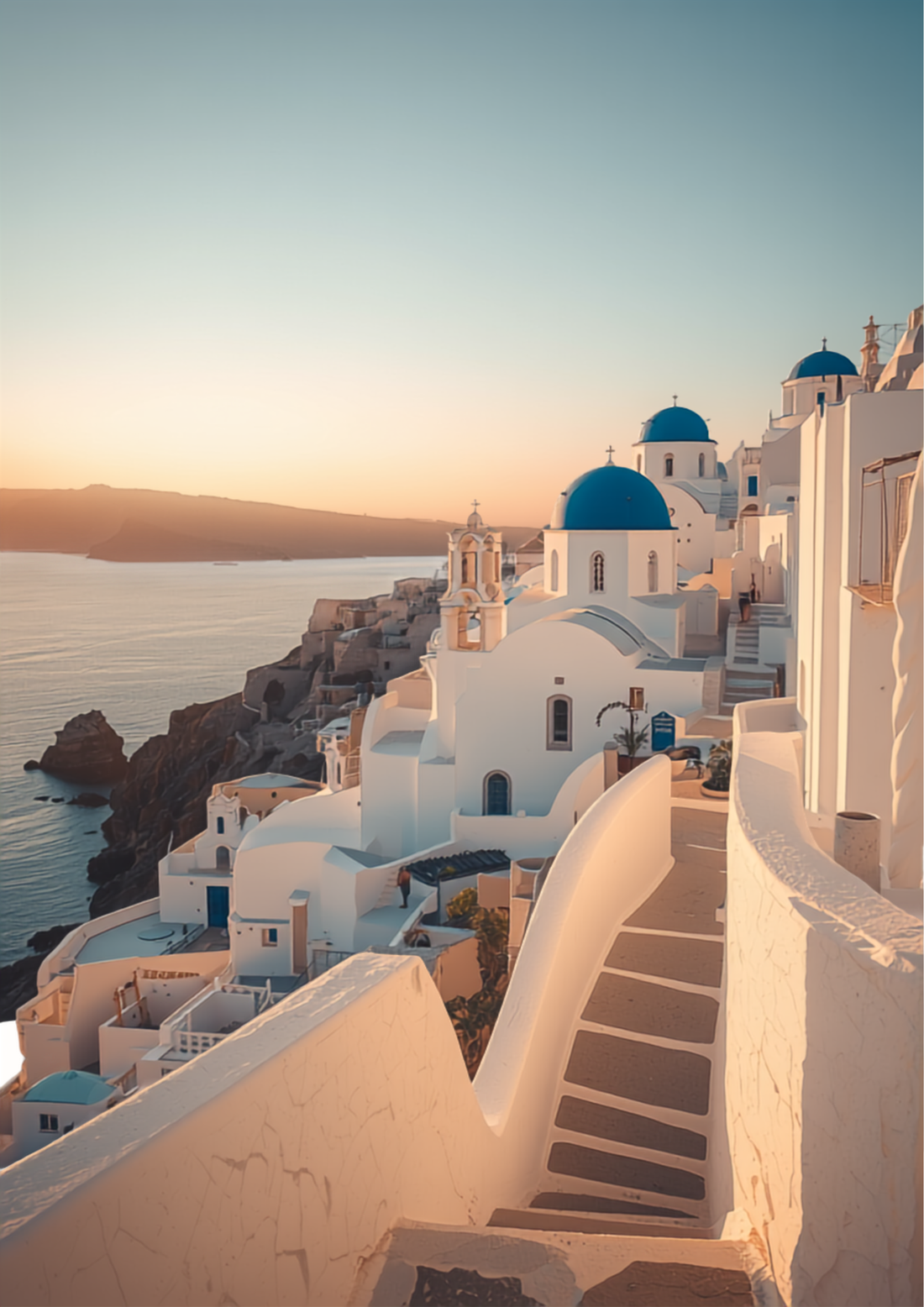 Iconic whitewashed Santorini buildings with blue domed churches at golden sunset