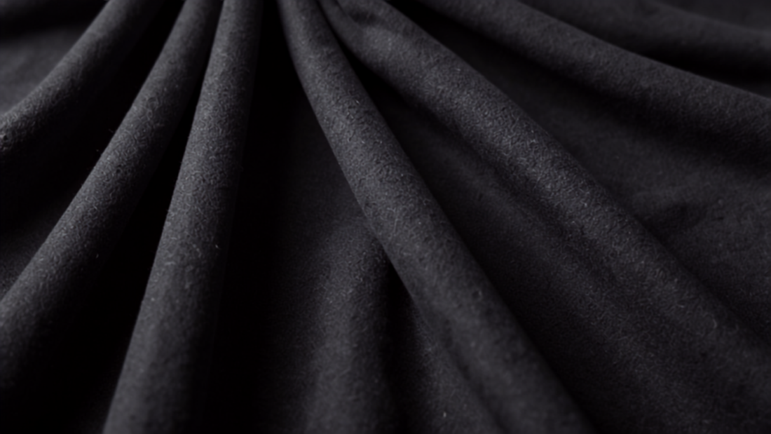 Pleated charcoal grey wool trouser fabric detail representing 2026 menswear staples