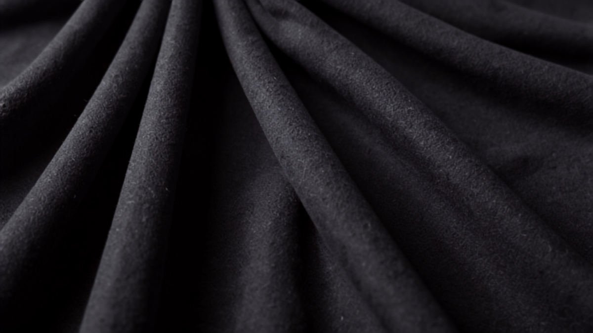 Pleated charcoal grey wool trouser fabric detail representing 2026 menswear staples