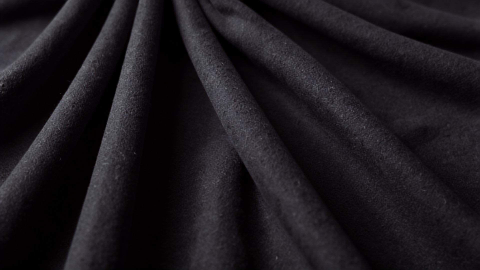 Pleated charcoal grey wool trouser fabric detail representing 2026 menswear staples