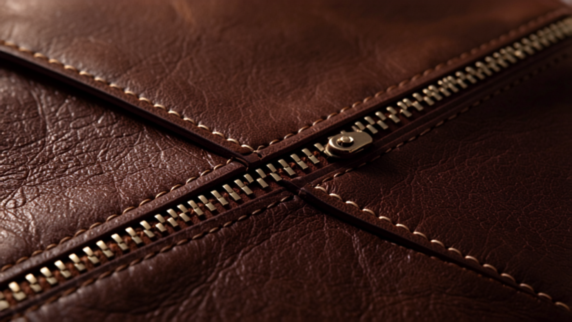 Close-up macro photography of brown leather duffel bag texture with zipper detail