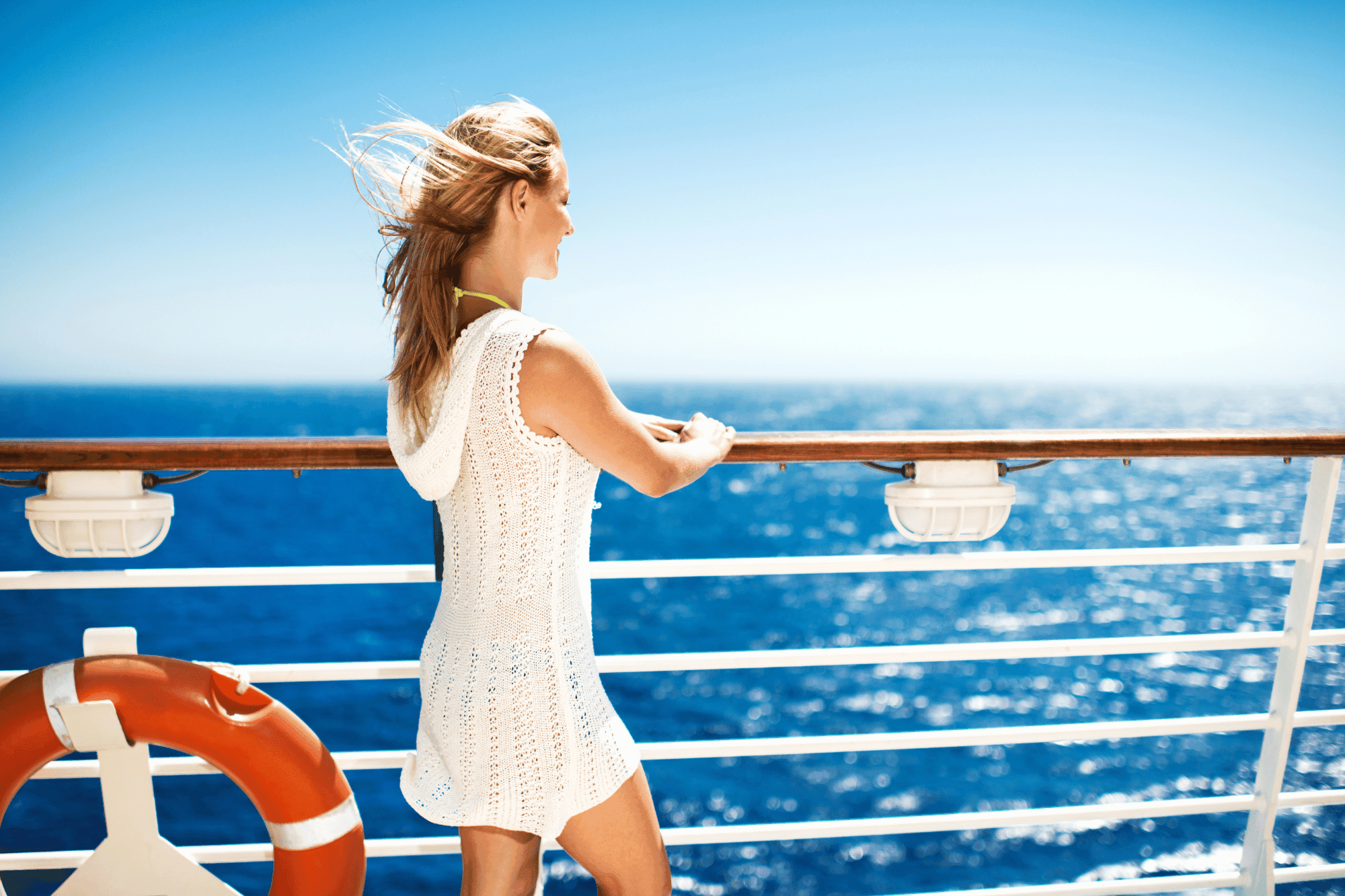 Woman in lightweight cover-up enjoying the ocean view, showcasing best clothing for cruise trips