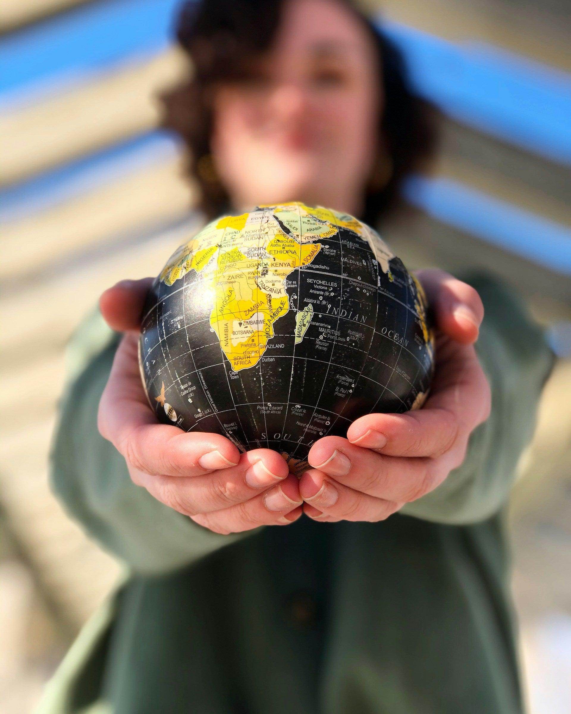 Traveler holding a globe representing top travel spots for solo female travelers worldwide