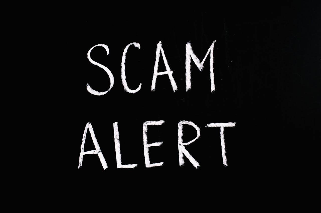 Scam alert warning written on a black background for how to spot travel scams