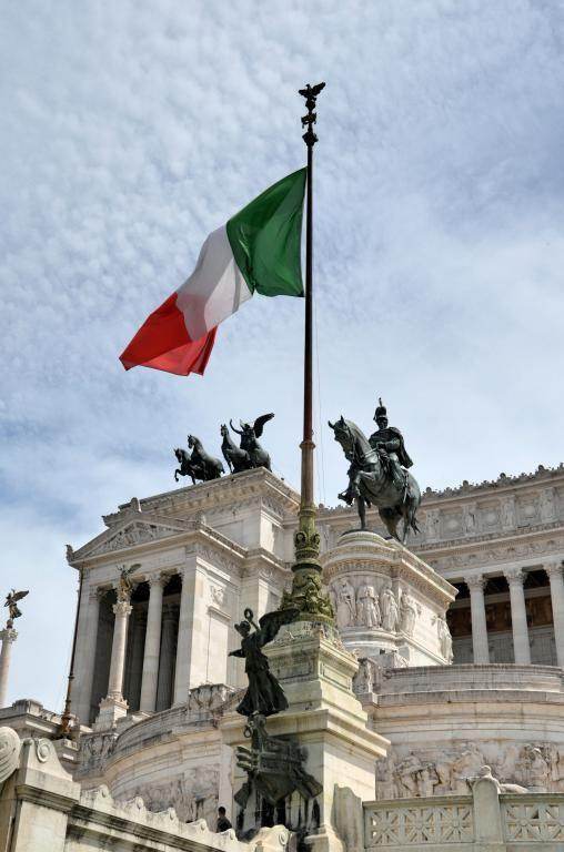 Italian flag flying over a historical monument in Rome, symbolizing quarantine-free flights to Italy 2023