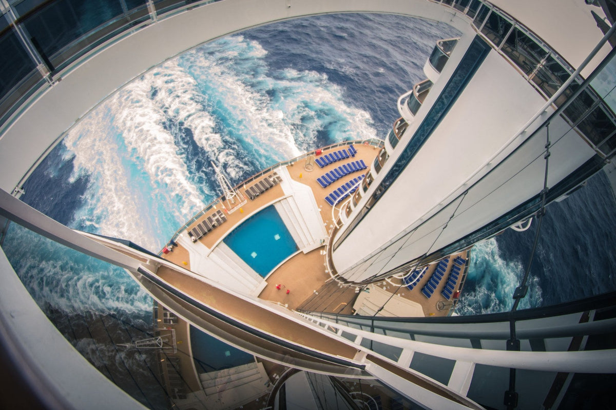 Aerial view of a cruise ship pool deck and wake at sea