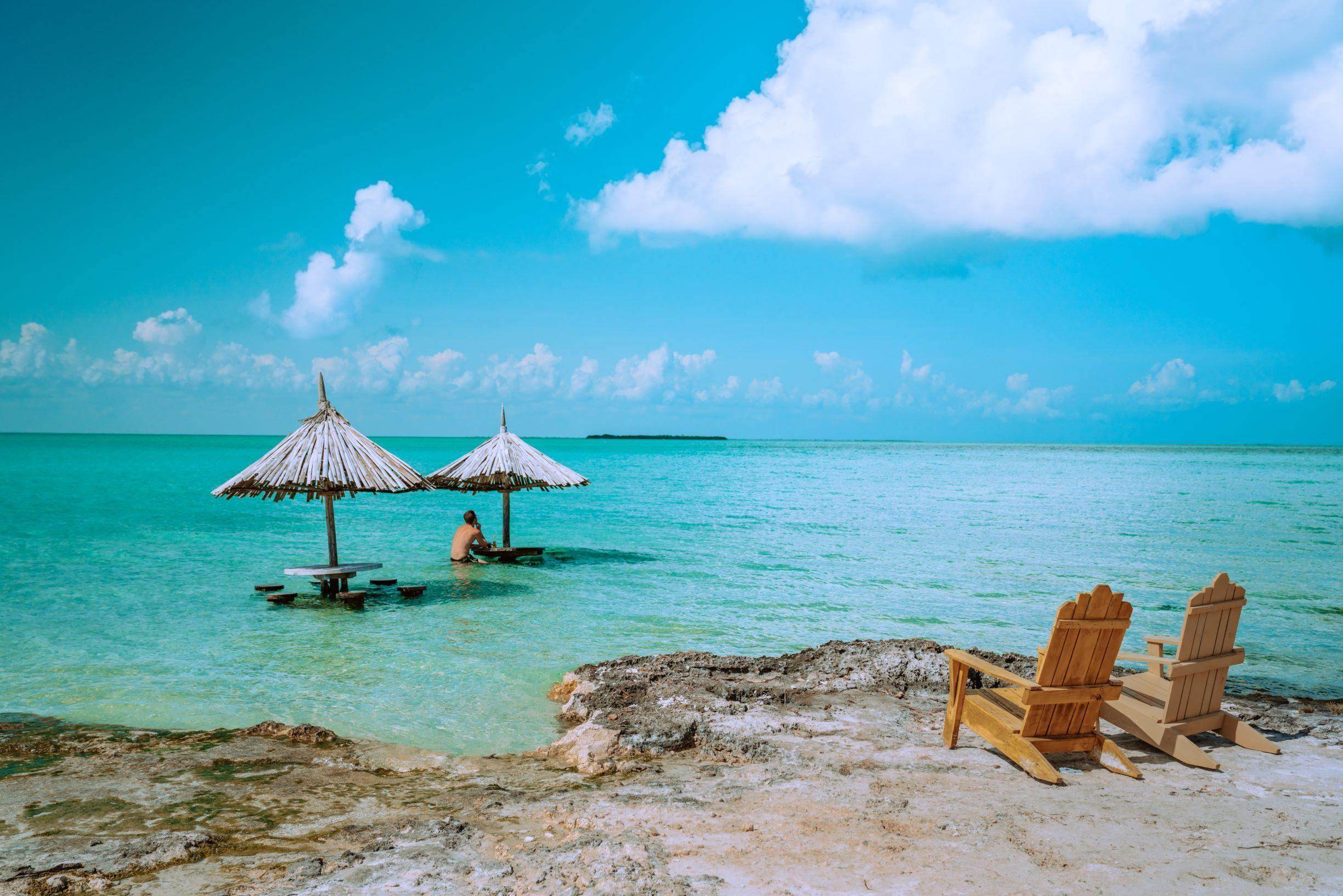 Beautiful Belize beach scene showcasing what to pack for Belize vacation with beach huts and turquoise water