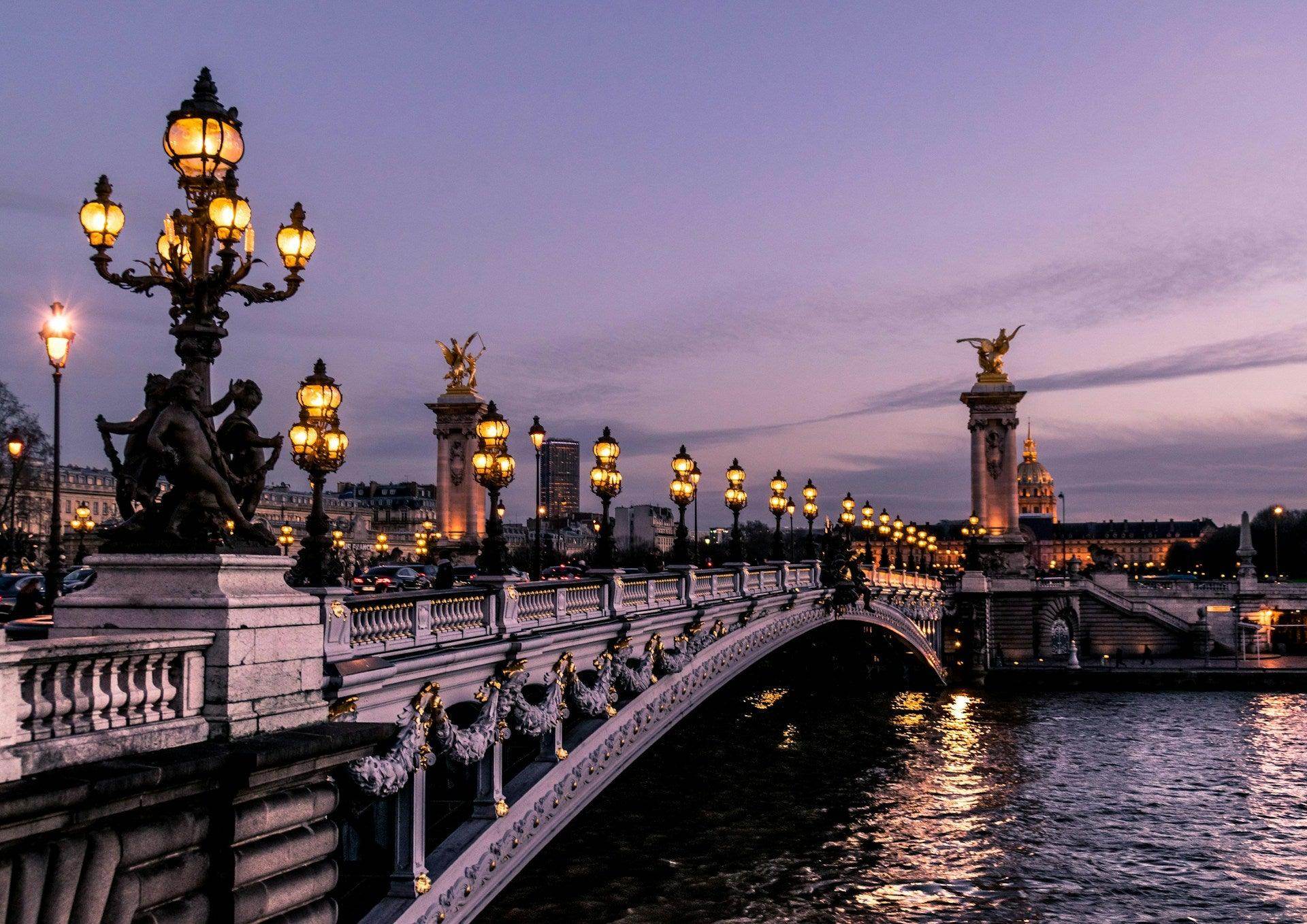 Scenic view of illuminated bridge in Paris with hints of France travel mistakes to avoid