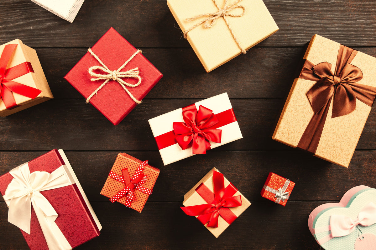 Wrapped holiday gift boxes with ribbons on a wooden table
