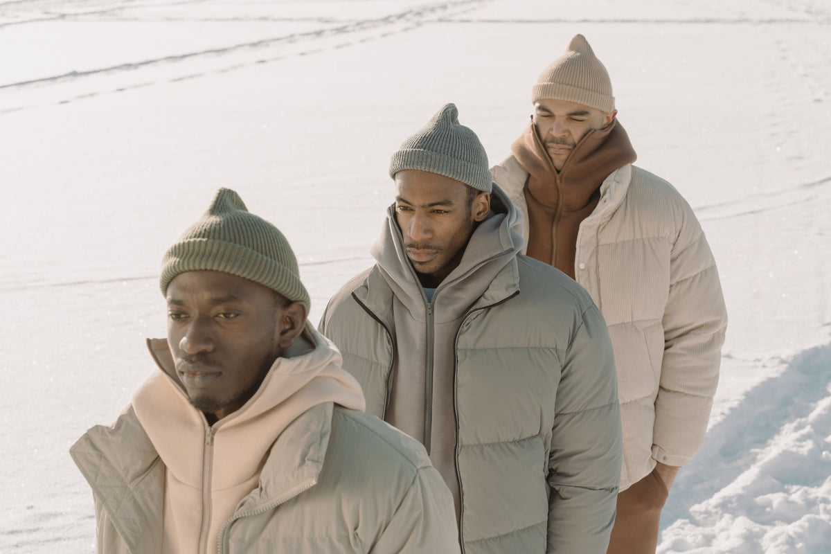 Travelers wearing puffer jackets and beanies in the snow