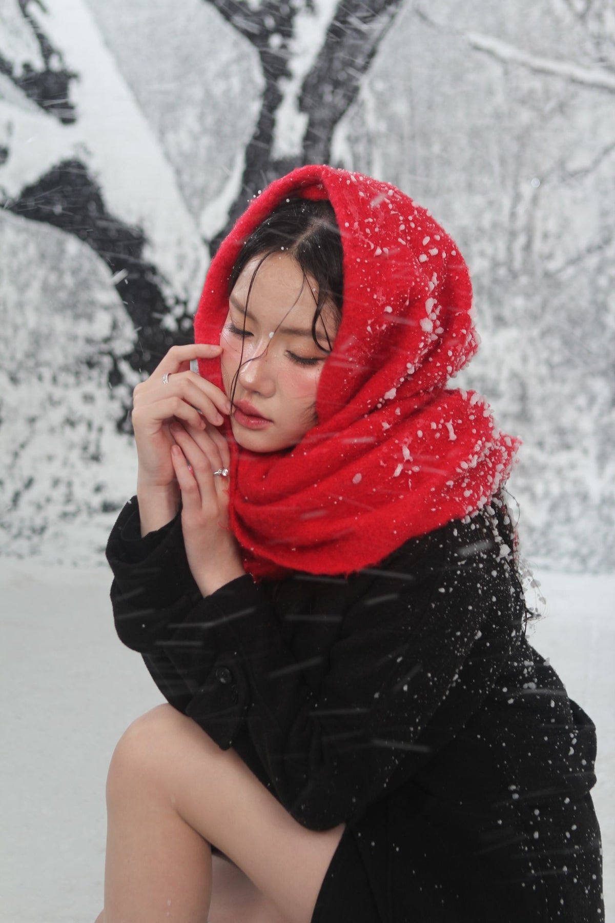 Woman wrapped in an oversized red knit travel scarf in the snow