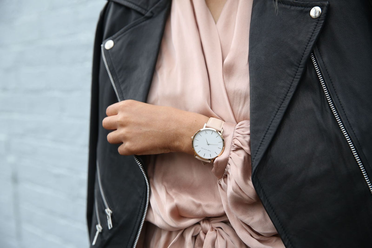 Woman wearing an elegant analog wristwatch with a leather jacket